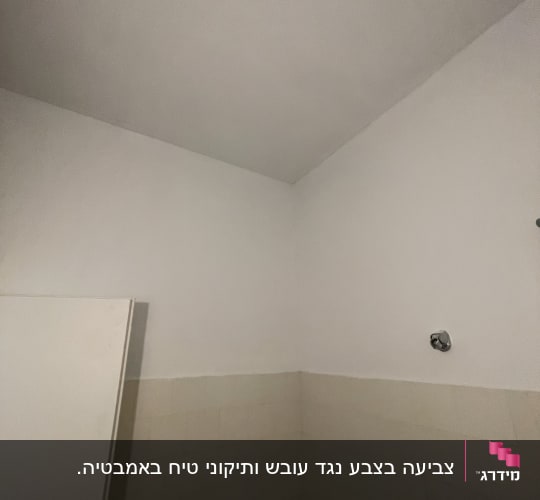 קיר ותקרה צבועים בלבן עם אריחים בהירים